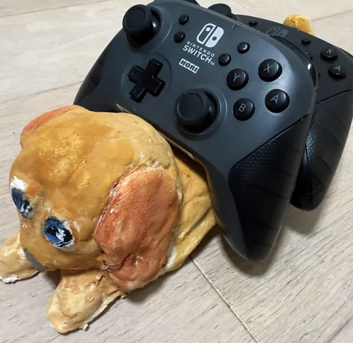 「ミニチュアダックスswitchコントローラー置き」じゅりちゃん（9歳）★目をウルウルに可愛くして尻尾でコントローラーを支えるようにしました。
